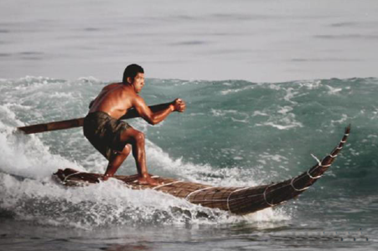 surfista no mar longboard e remo artesanal